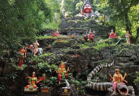 Colorful statues of deities and Ganesha on a limestone cliff at Wat Tham Ta Pan Unseen Phang Nga attraction