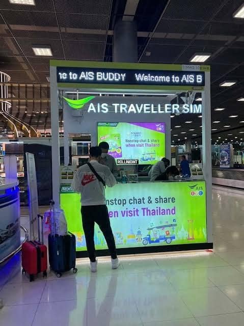 Tourist buying AIS SIM card Phuket Airport queue arrival Thailand