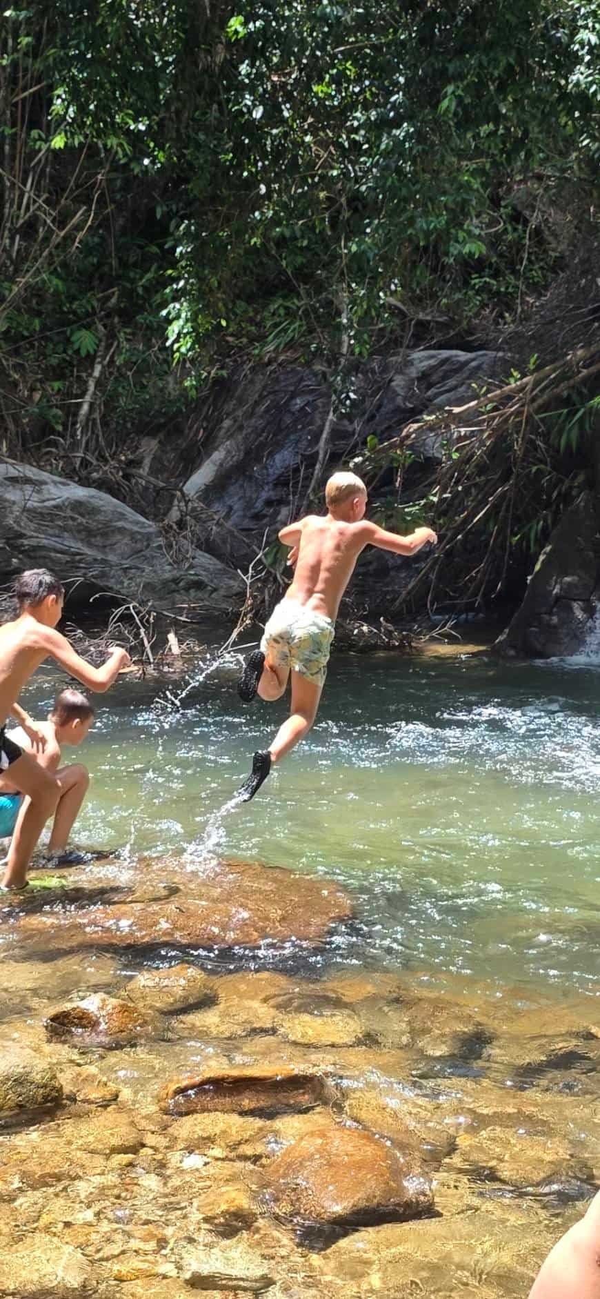 A child jumping into the natural pool at the waterfall on the Khao Lak Safari